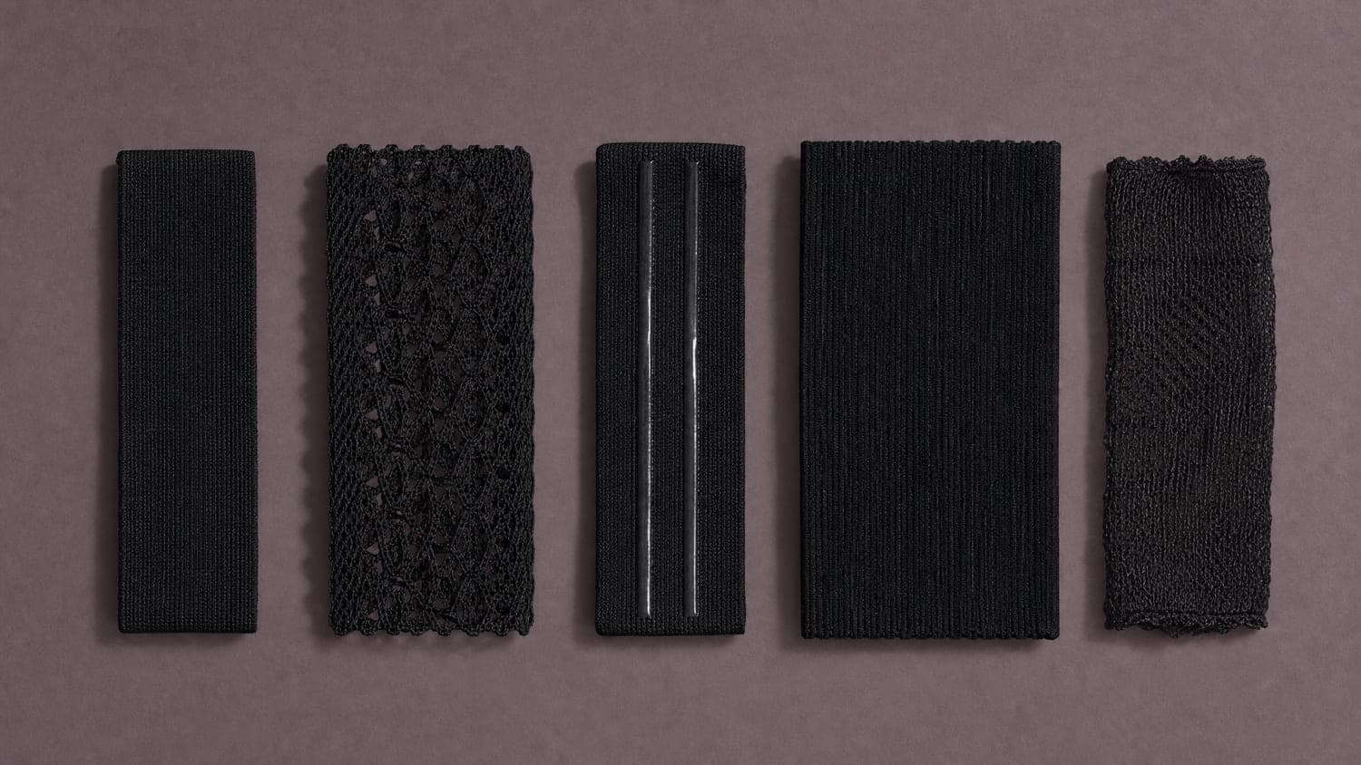 Five hosiery welts laid flat in a row: plain, lace, silicone-lined, wide and non-marking